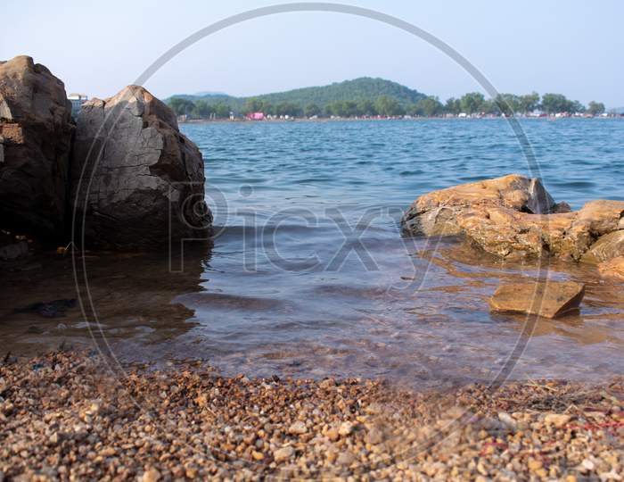 Small Waves In A Lake Meeting The Shore Captured From Low Angle