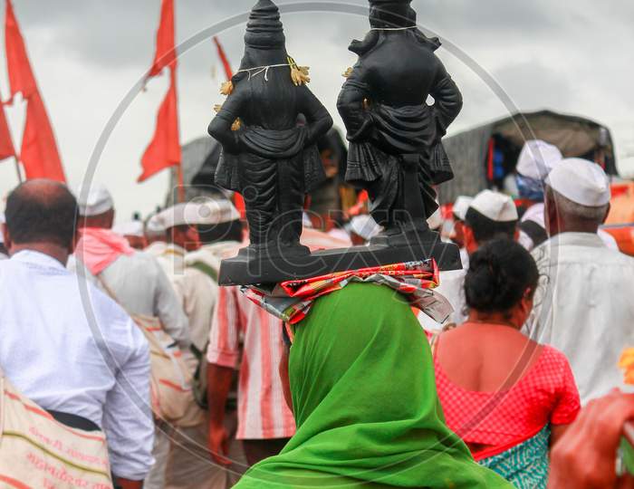 A woman carrying deity idols on her head