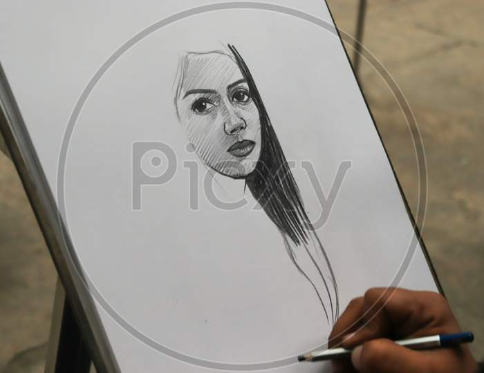 A Punjabi Boy Drawing A Sketch Of Beautiful Girl On White Paper With Pencil At Rock Garden, Uttar Marg, Rock Garden Of Chandigarh, Sector 1, Chandigarh