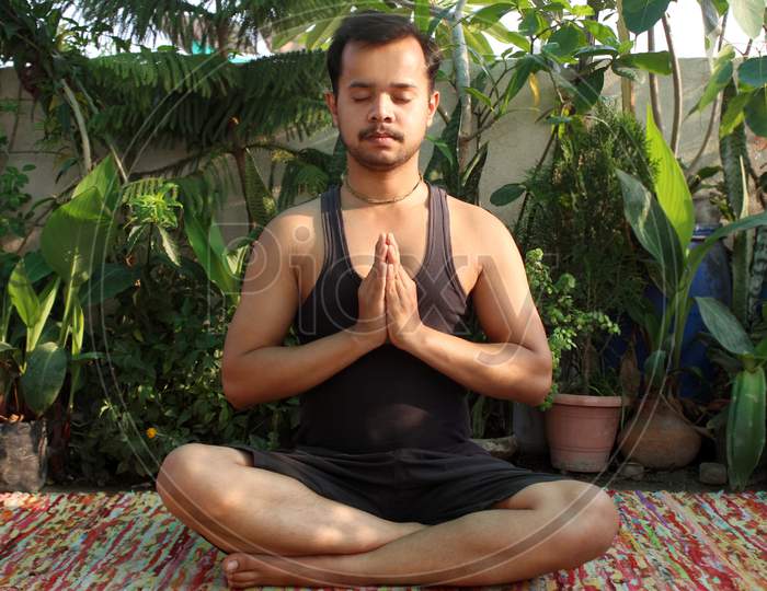 portrait of Asian man practicing meditation, yoga exercise at home