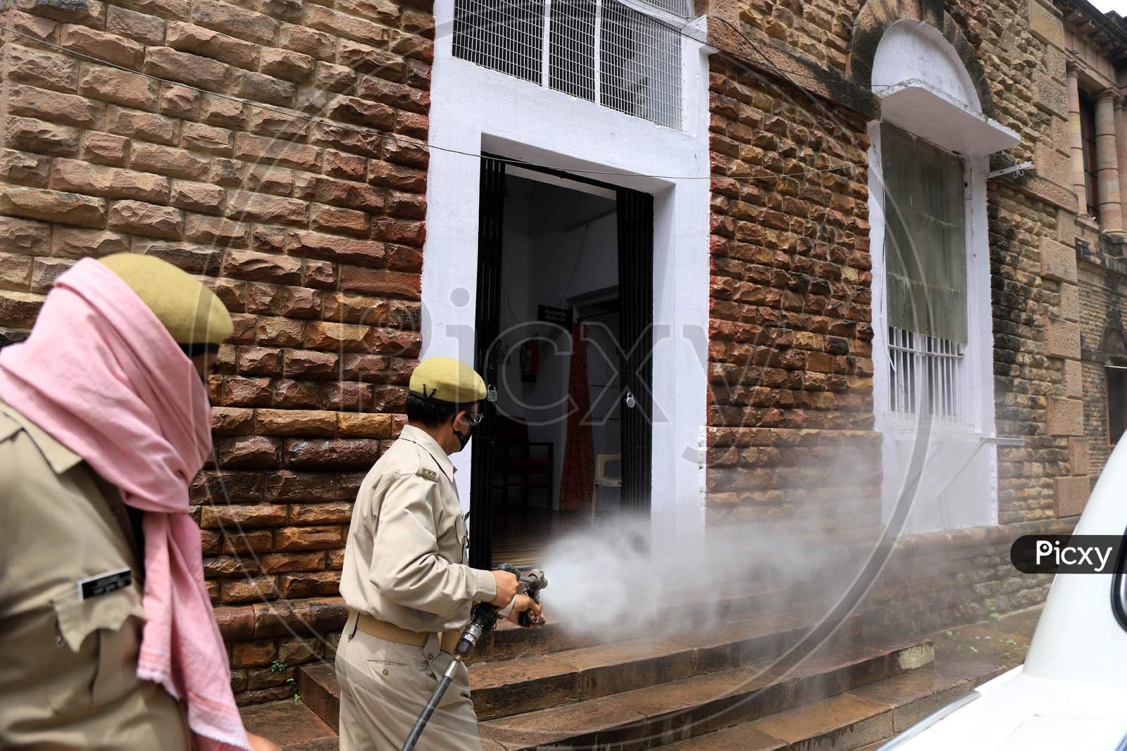 Firefighters Spray Sanitizer On A Car During A Nationwide Lockdown Amidst COVID-19 or Coronavirus Outbreak In Prayagraj, April 20, 2020