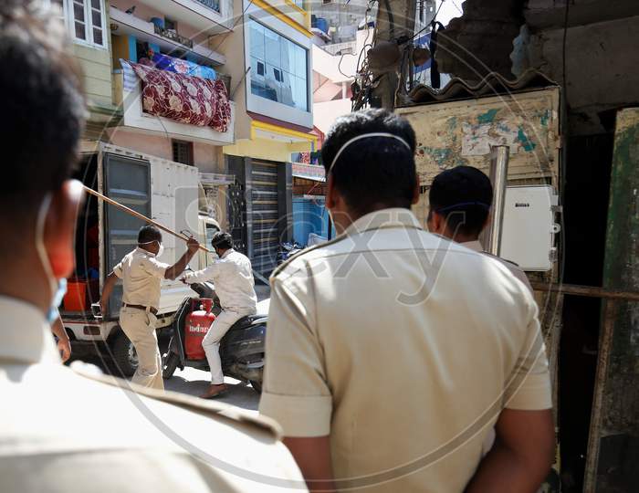 A Police Lashing lati or Stick On a Commuter for Trespassing the Lockdown rules  During Corona Virus or COVID-19 Pandemic in Bangalore City