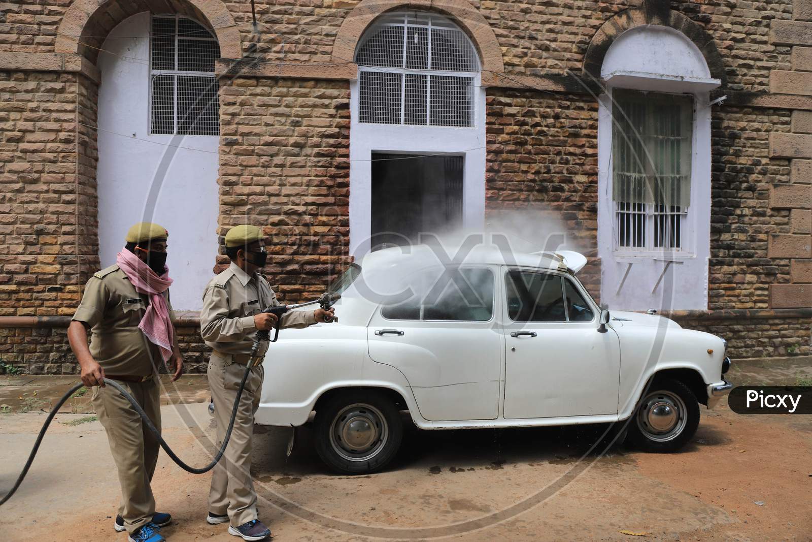 Firefighters Spray Sanitizer On A Car During A Nationwide Lockdown Amidst COVID-19 or Coronavirus Outbreak In Prayagraj, April 20, 2020