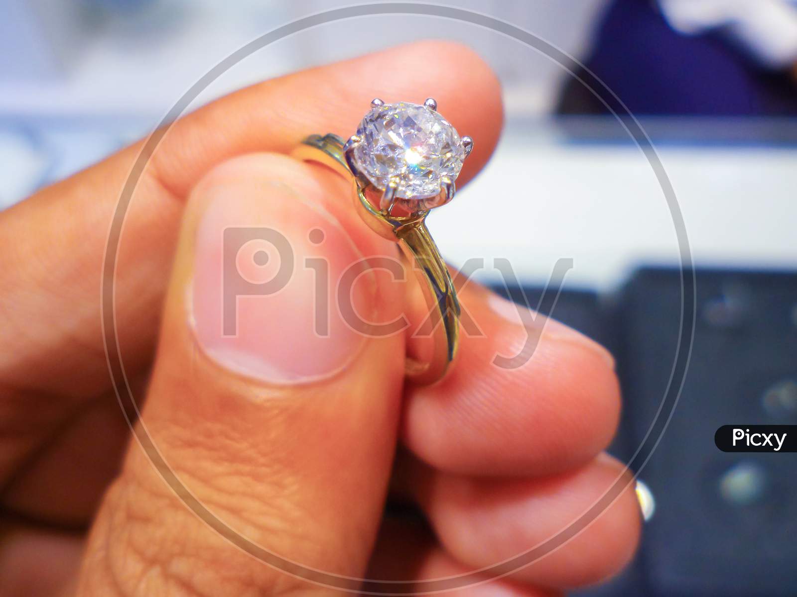 Male Jeweler Holding Diamond Ring, Closeup View