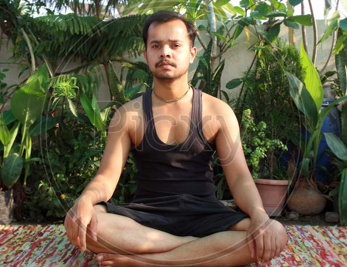 portrait of Asian man practicing meditation, yoga exercise at home
