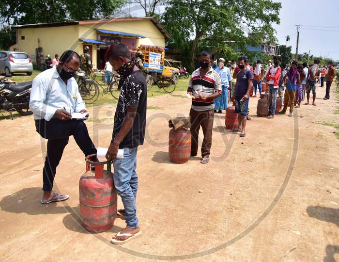 People Maintain Social Distance As They Wait In A Queue  To Collect  Lpg Gas Cylinder  During A Nationwide Lockdown In The Wake Of Coronavirus (COVID-19)  Pandemic, At Samaguri In Nagaon District Of Assam On  Tuesday, April 21, 2020