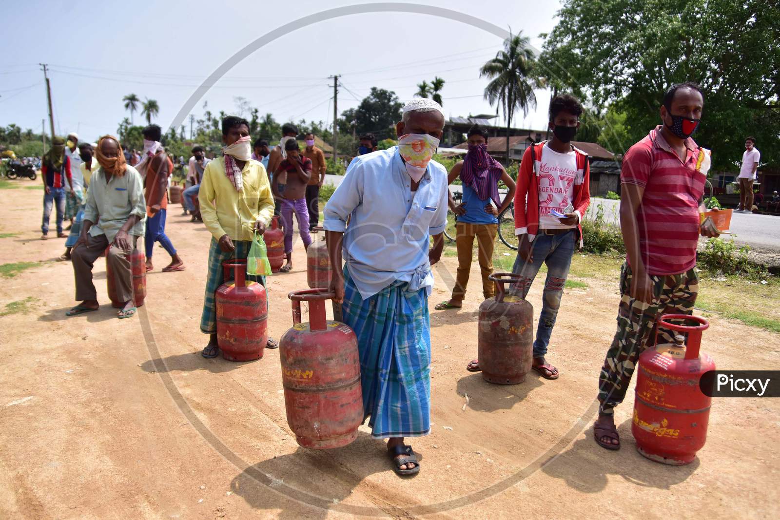 People Maintain Social Distance As They Wait In A Queue  To Collect  Lpg Gas Cylinder  During A Nationwide Lockdown In The Wake Of Coronavirus (COVID-19)  Pandemic, At Samaguri In Nagaon District Of Assam On  Tuesday, April 21, 2020