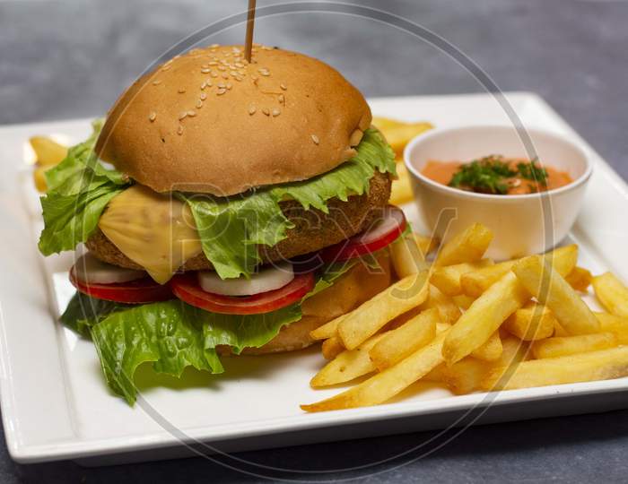 Burger with fresh lettuce, tomato, onion and cheese served with french fries