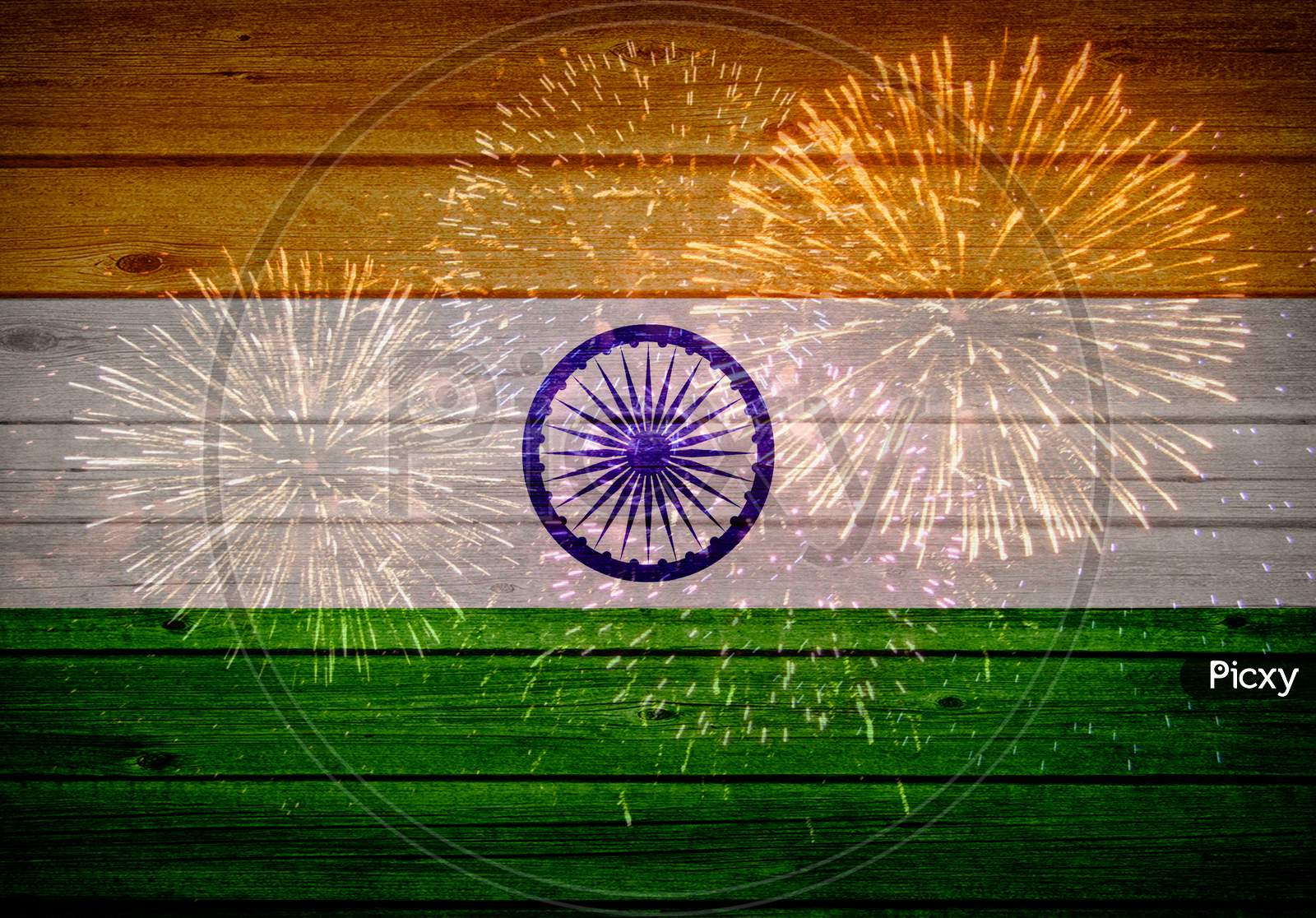 Indian flag painted on wooden texture with fireworks background.