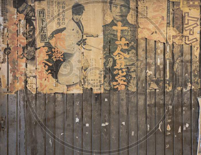 Old vintage retro japanese movie posters on underpass Yurakucho Concourse wall under the railway line of the station Yurakucho. Japanese noodle stalls and sake bars revive the nostalgic years of Showa air with old samurai posters and placards glued to the walls of the tunnel.