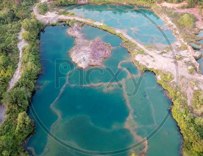 Guar Petai With Turquoise Green Lake Beside Oil Palm Plantation.