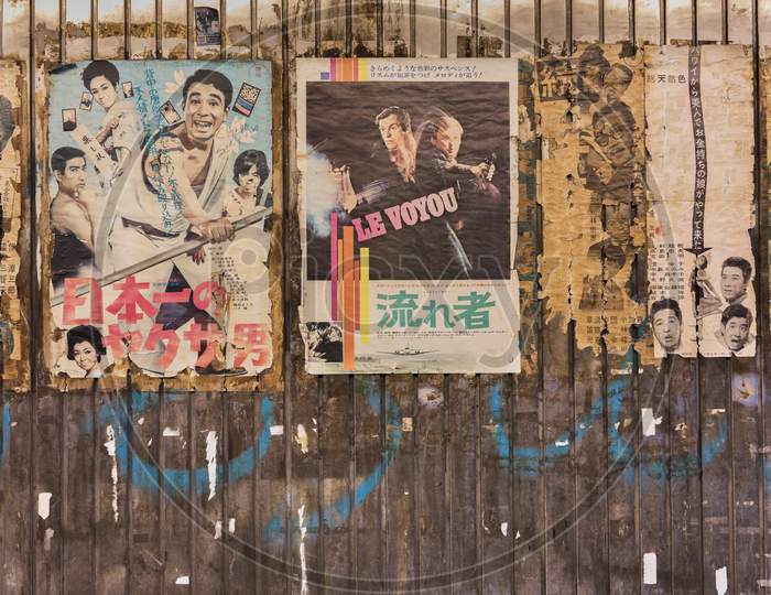 Old vintage retro japanese movie posters on underpass Yurakucho Concourse wall under the railway line of the station Yurakucho. Japanese noodle stalls and sake bars revive the nostalgic years of Showa air with old samurai posters and placards glued to the walls of the tunnel.