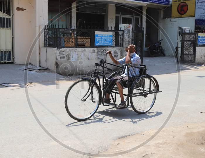 A Physically Challenged Man Riding a Tricycle on empty Roads During Nationwide Lockdown Amidst Coronavirus or COVID-19 Outbreak in Prayagraj