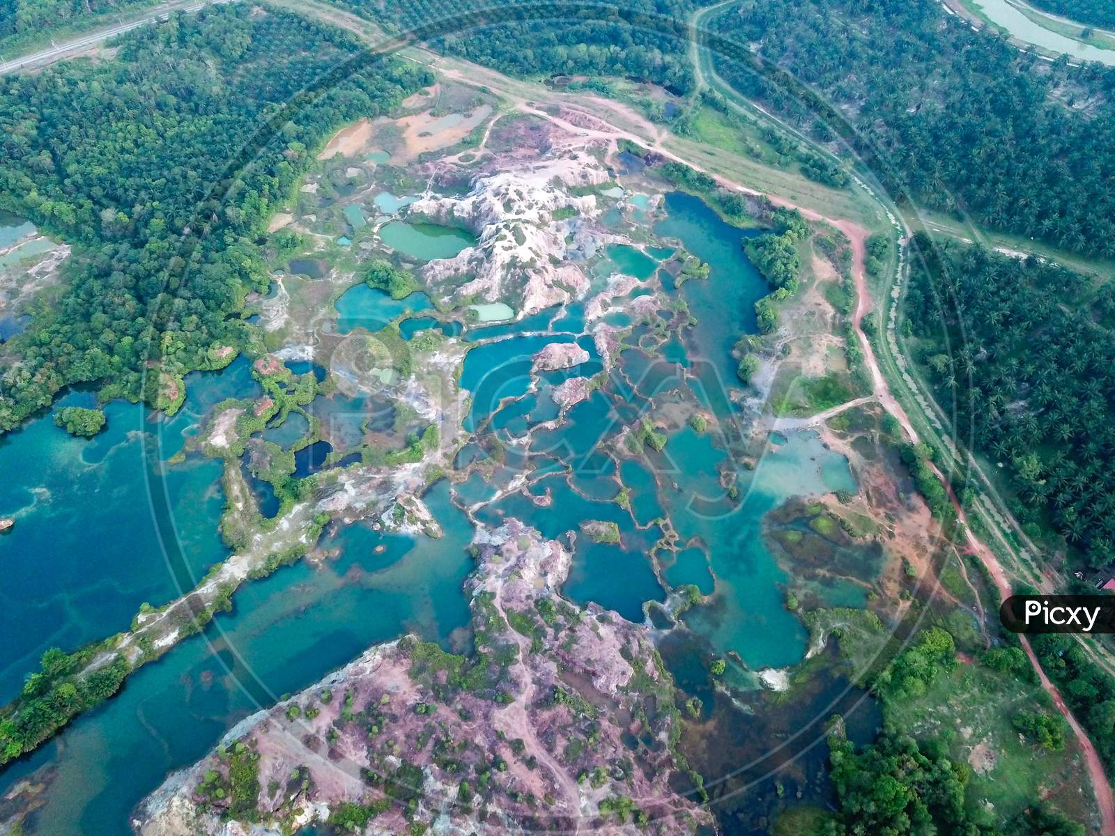 Aerial View Green Lake At Guar Petai Surrounded By Green Trees.