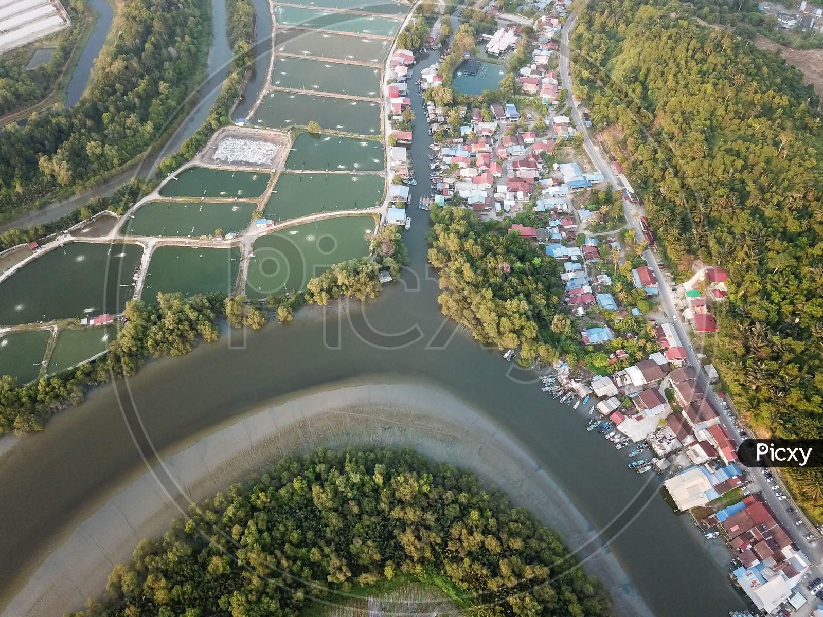 Aerial View Fishing Village And Fish Farms Beside River.