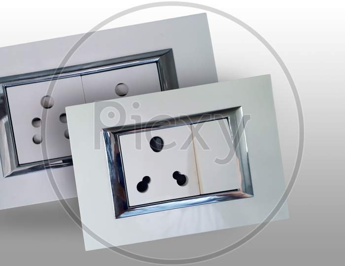 Indian style electric socket with auto shutter and shiny steel strip for wall fitting made with bakelite plastic insulator and consist of a socket and a switch -isolated image