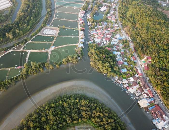 Aerial View Fishing Village And Fish Farms Beside River.