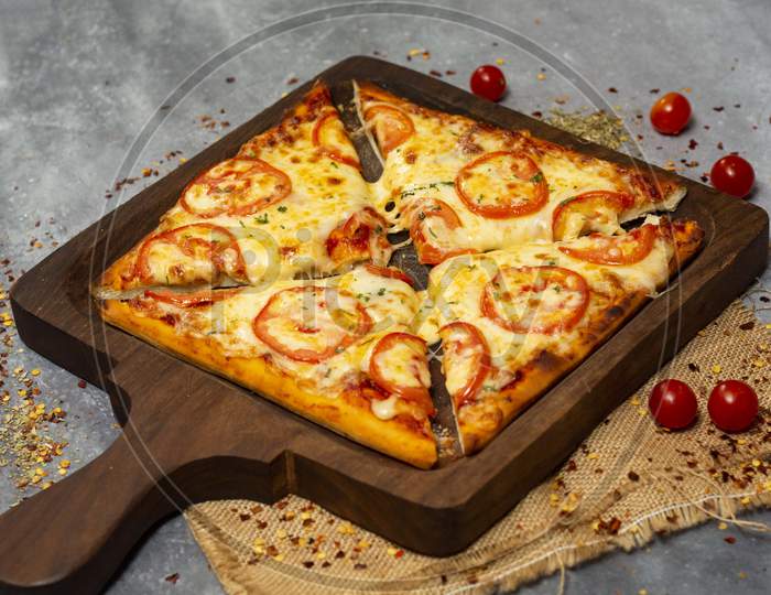 Square shaped margherita pizza on wooden pan