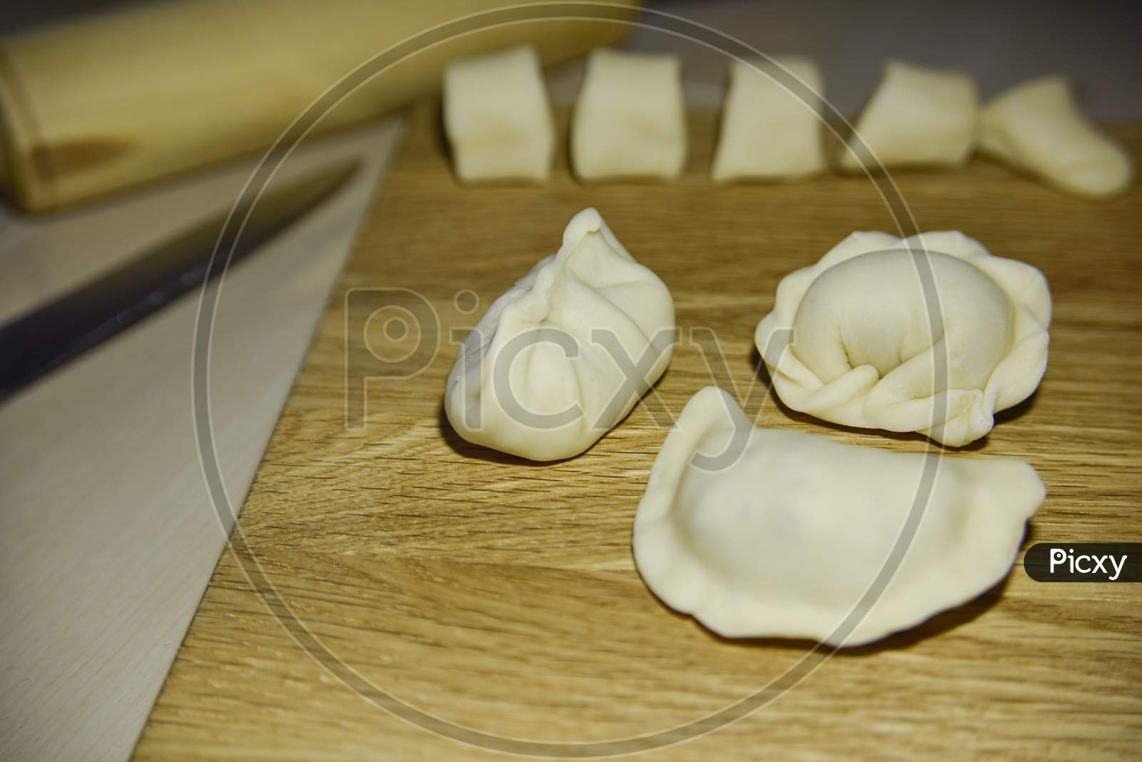 Three Dumplings Of Different Shape On The Wooden Deck. Selective Focus. Close-Up Look.