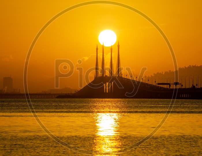 Gold Egg Yolk Sun Over Mid Span Of Penang Bridge.