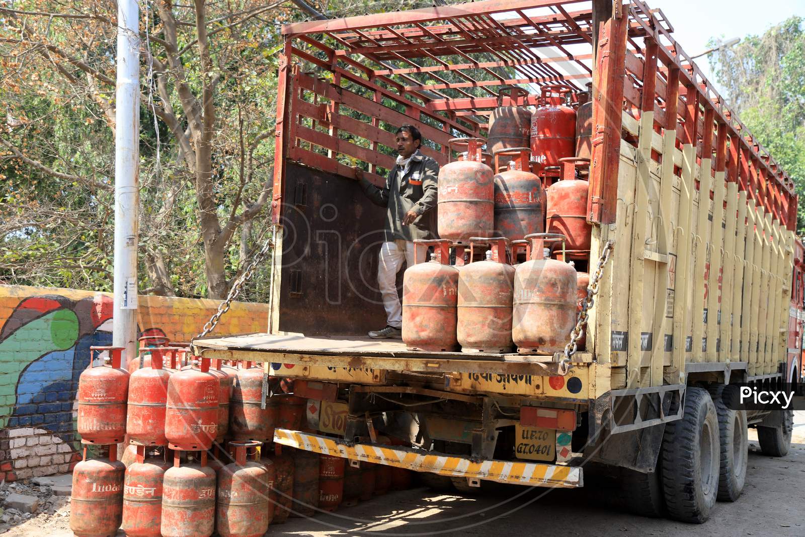 A man Unloads LPG Cylinders From a Vehicle During Nationwide Lockdown For Coronavirus Or COVID-19  Outbreak In Prayagraj