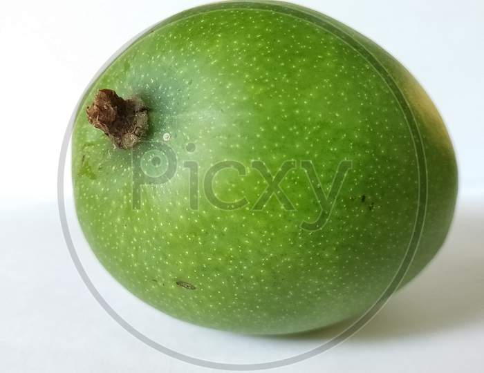Green mangoes on white background. Fresh mangoes on plain background. Green fruits close up.