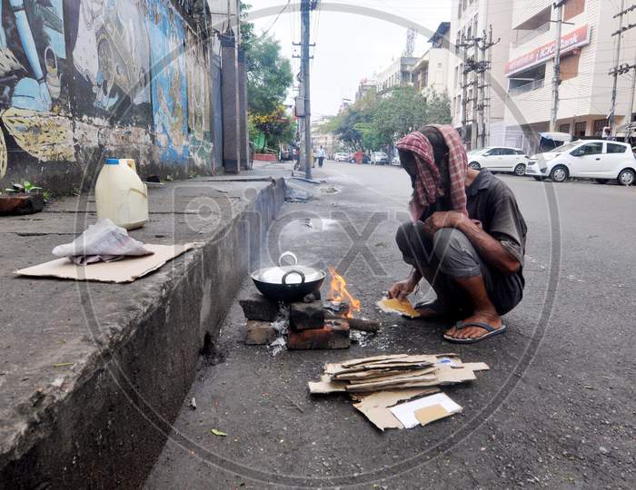 A Homeless Man Preparing  Food On The Deserted Street During Nationwide Lockdown Amidst Coronavirus or COVID-19 Outbreak in Guwahati April 24,2020