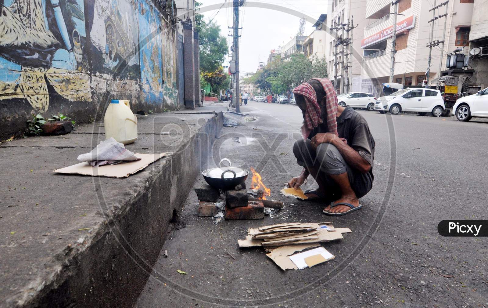 A Homeless Man Preparing  Food On The Deserted Street During Nationwide Lockdown Amidst Coronavirus or COVID-19 Outbreak in Guwahati April 24,2020