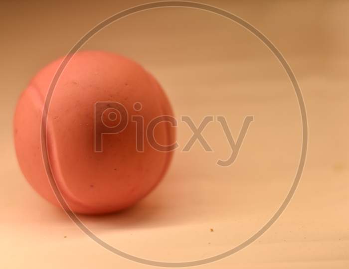 closeup of a pink playing ball on white background