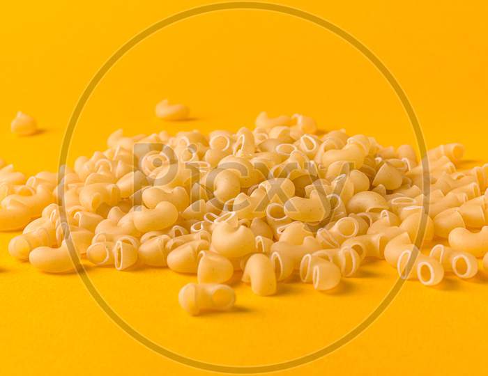 Uncooked macaroni elbow shape pasta with white background stock image.