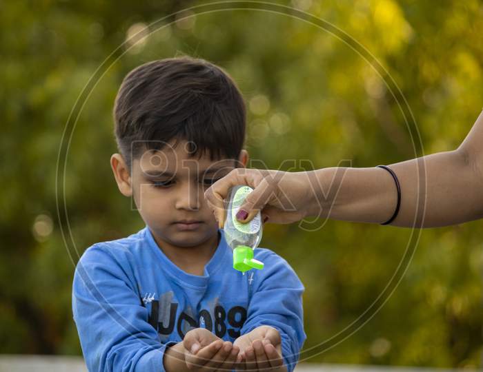 Indian Child Using Sanitizer For Protection From Corona Virus
