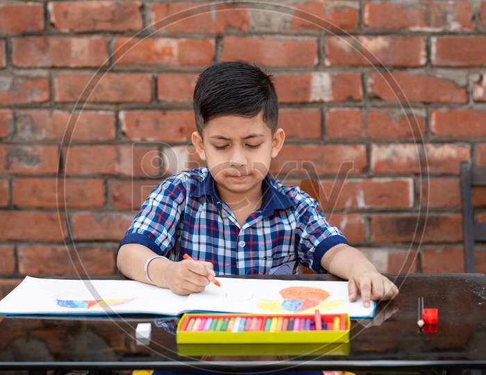 Indian schoolkid in uniform drawing and learning painting in classroom, Indian primary school education concept.