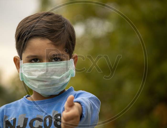 Indian Child With Mask Showing Thumbs Up During Corona Virus Lockdown Days In India