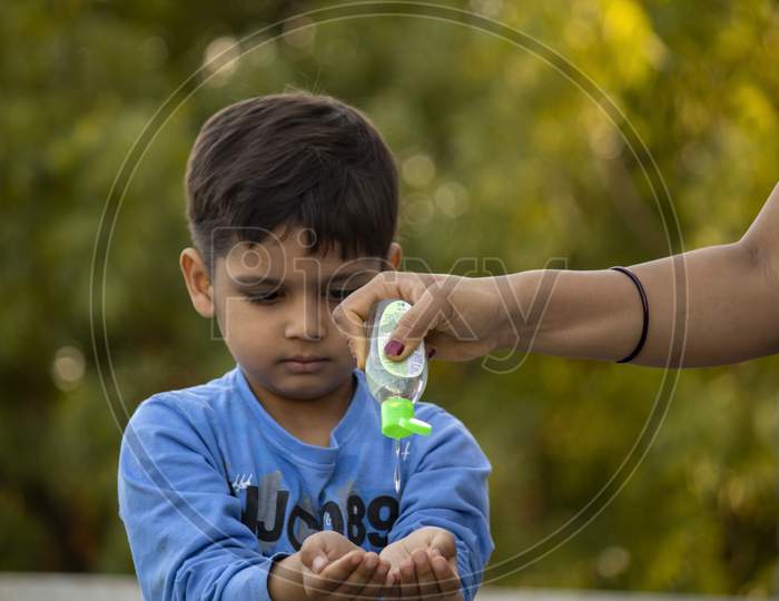 Indian Child Using Sanitizer For Protection From Corona Virus