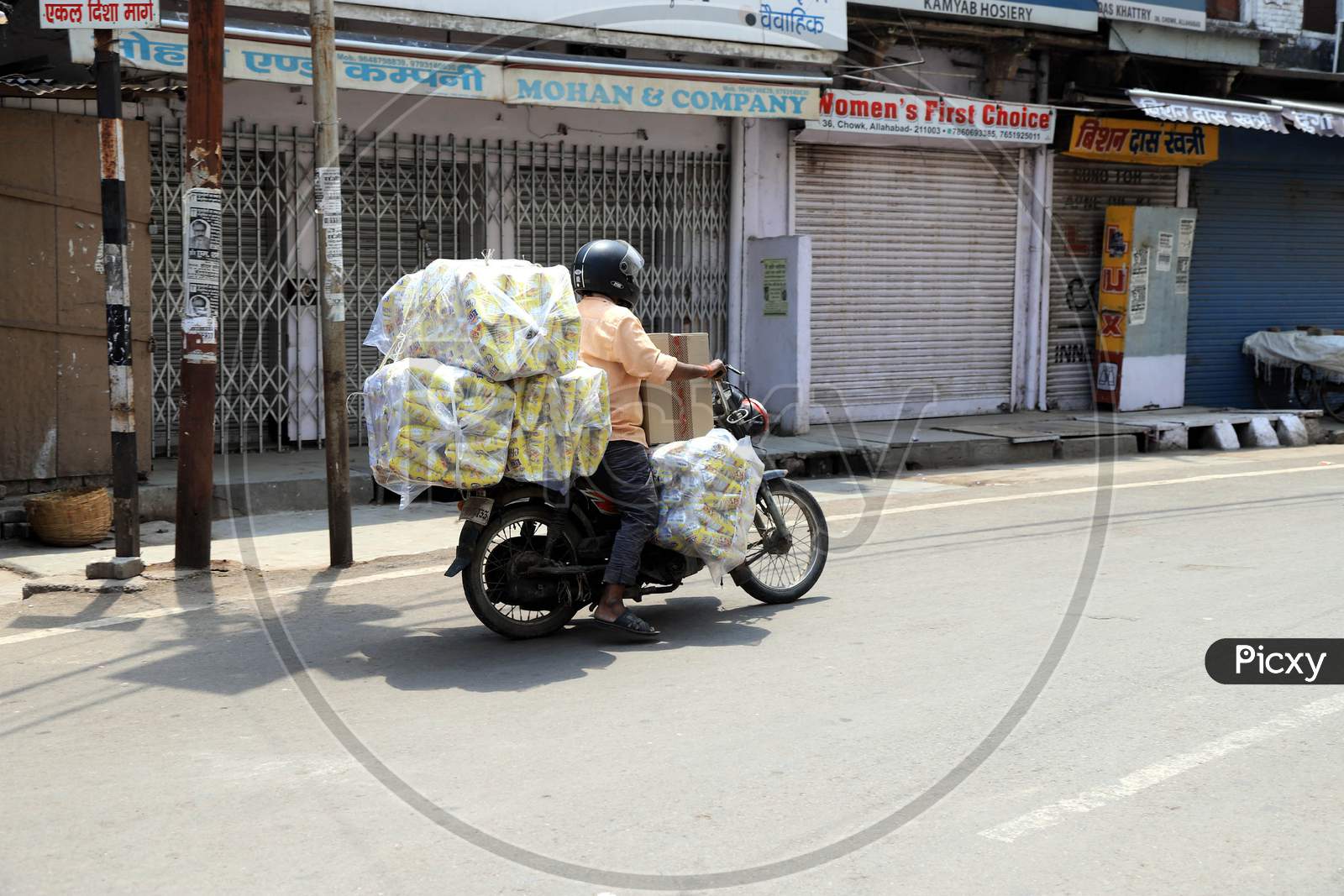 A Vendor Carries  Goods on  Bike On Empty Roads during Nationwide Lockdown Amidst Coronavirus or COVID-19 Outbreak In Prayagraj