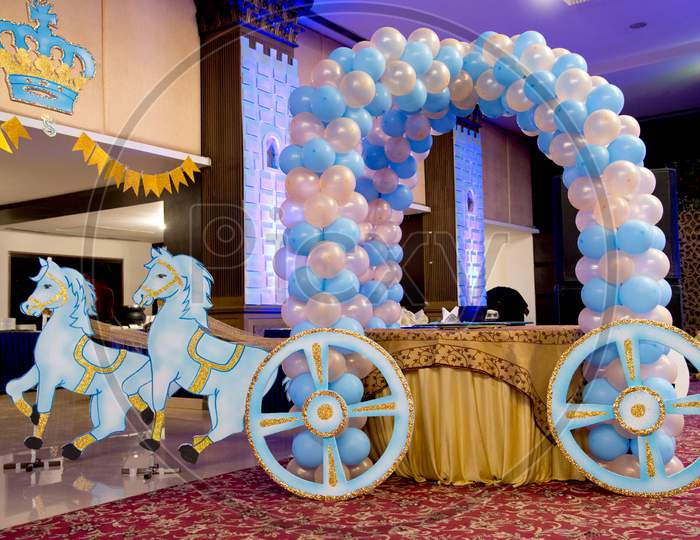 royal horse cart decoration in a birthday party with cake and balloons.