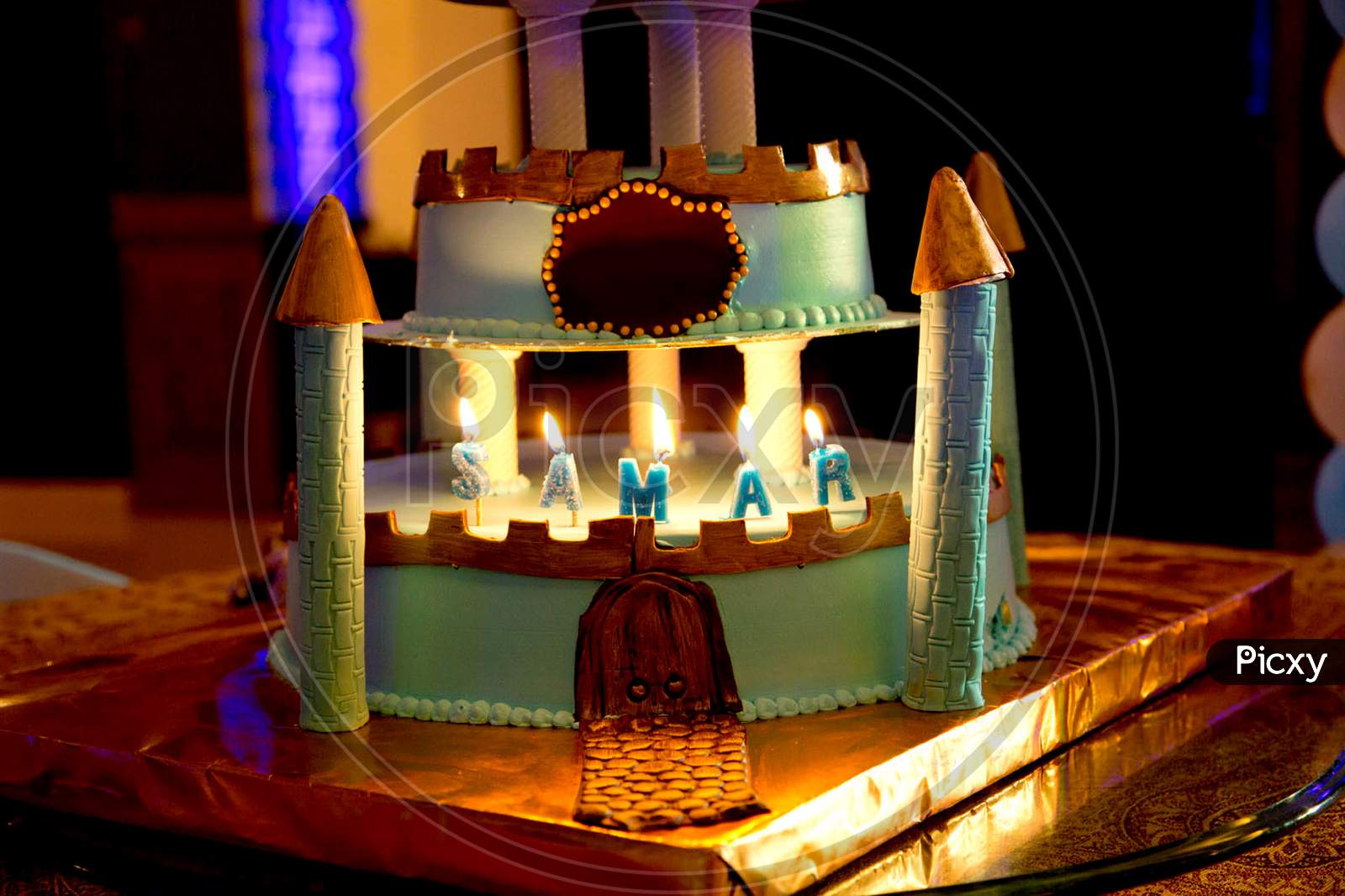 green castle birthday cake with burning candle for kids party