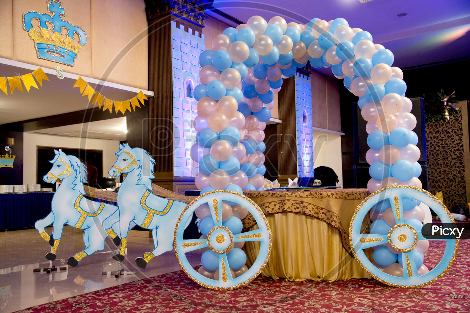 royal horse cart decoration in a birthday party with cake and balloons.