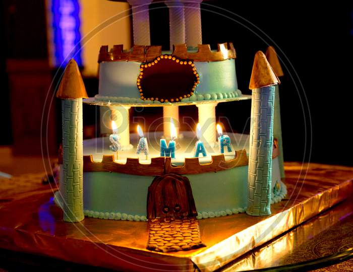 green castle birthday cake with burning candle for kids party