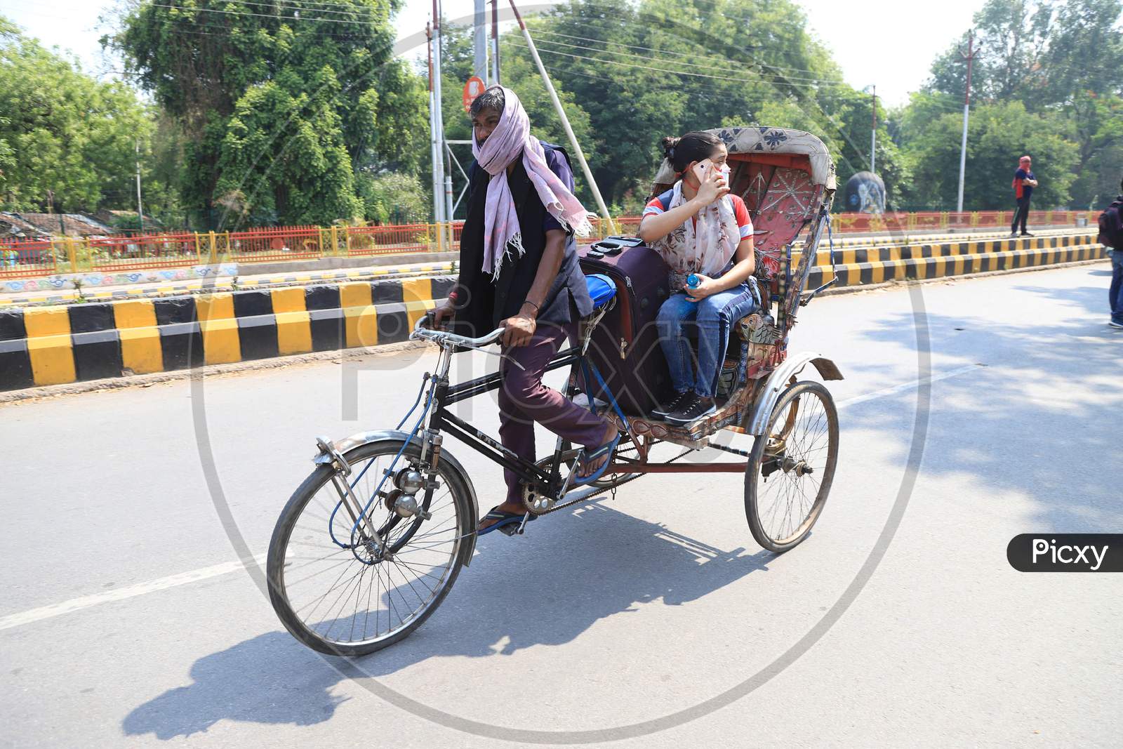 A girl takes a rikshaw ride in Prayagraj to board a bus to reach her hometown as arranged by the Uttar Pradesh government as a preventive measure against the COVID-19 in addition to the government imposed nationwide lockdown, April 28, 2020.