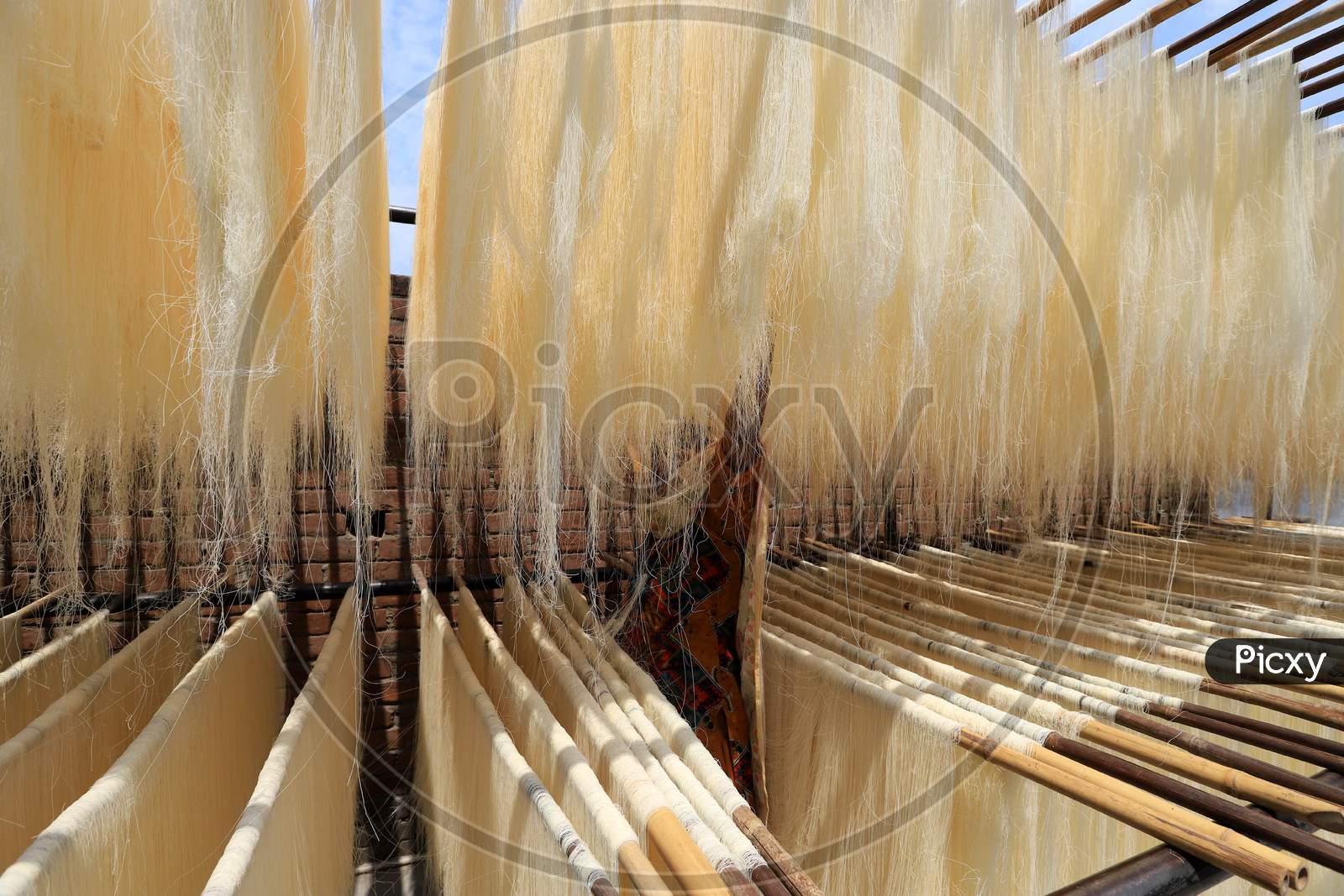 A woman spreads strands of vermicelli, a specialty eaten during the holy month of Ramadan, to dry it at a factory during a nationwide lockdown to slow the spreading of the coronavirus disease (COVID-19), in Prayagraj, April 28, 2020.