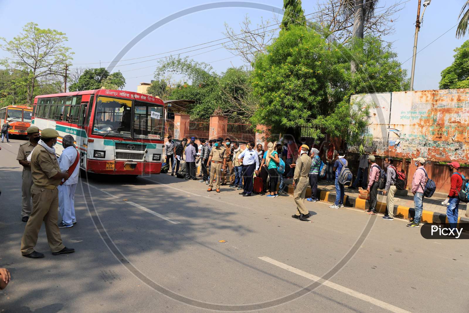 People waiting in a queue to board buses arranged by Uttar Pradesh government to reach their arranged by the Uttar Pradesh government to send them to their hometowns as a preventive measure against the COVID-19 in addition to the government imposed nationwide lockdown.