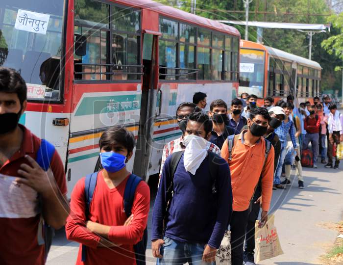 People waiting in a queue to board buses arranged by Uttar Pradesh government to reach their arranged by the Uttar Pradesh government to send them to their hometowns as a preventive measure against the COVID-19 in addition to the government imposed nationwide lockdown.
