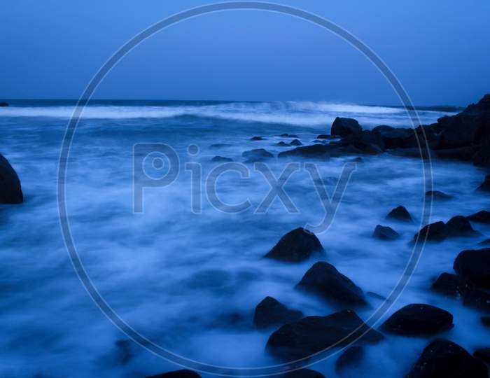 Seascape Beach Waves With Rocks On Long Exposure At Mahabalipuram Beach. Motion Blur Photography.