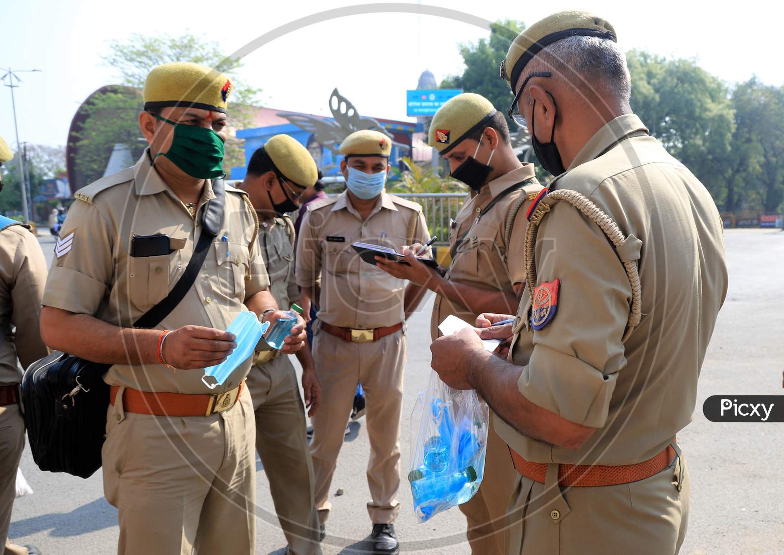A police man distributes mask to other policemen during a government-imposed nationwide lockdown as a preventive measure against the COVID-19 corona virus in Prayagraj, April 28, 2020.