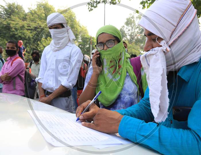 An employee in Prayagraj writes down details of students boarding the buses arranged by the Uttar Pradesh government to send them to their hometowns as a preventive measure against the COVID-19 in addition to the government imposed nationwide lockdown, April 28, 2020.