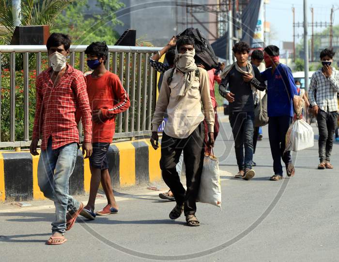 Migrant laborers walk on the road during government imposed nationwide lockdown as a preventive measure against the COVID-19 coronavirus in prayagraj, April 29, 2020.
