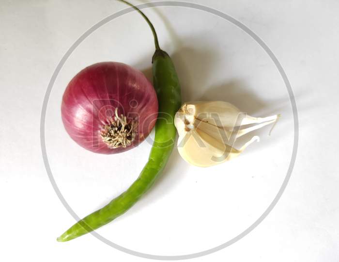 Onion and garlic and green chillies on white background. Kanda lasun mirchi photo. Fresh vegetables on plain background.