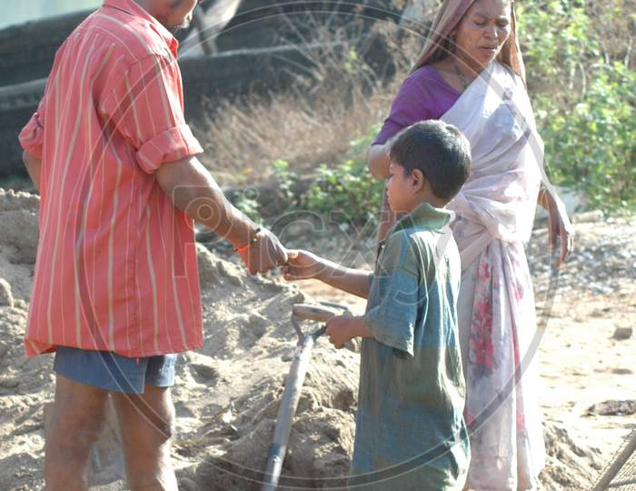 Indian Boy Helping His Father Working In Fields