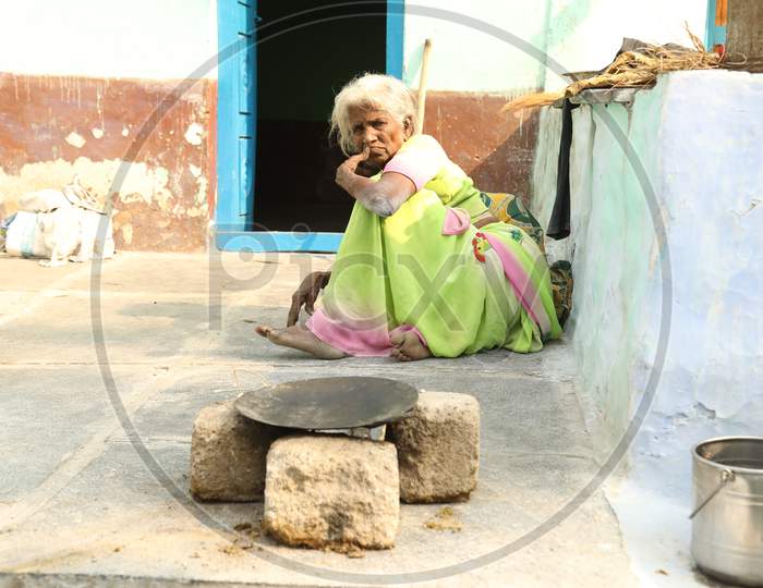 An Elderly Woman Sitting In an Rural Village Poor House